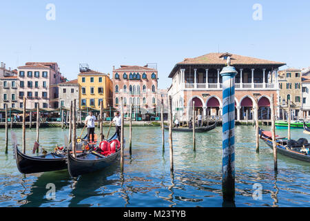 Deux gondoliers aller chercher leurs gondoles devant le marché aux poissons du Rialto sur le Grand Canal, San Polo, Venise, Vénétie, Italie au début de la journée dans sp Banque D'Images