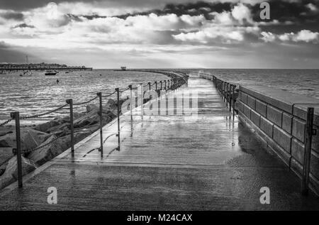 Image en noir et blanc du brise-lames, connu sous le nom de Neptune's Arm à Herne Bay, Kent, UK lors d'une marée haute lorsque l'allée humide a été fermée en raison de vagues Banque D'Images