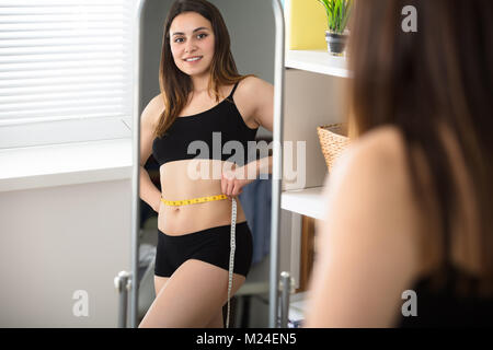 Close-up of a Woman's réflexion dans son ventre De Mesure miroir Banque D'Images
