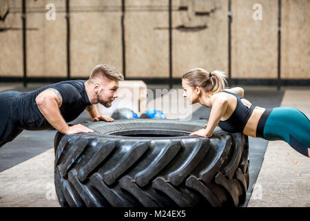 Couple poussant dans la salle de sport de l'onduleur Banque D'Images