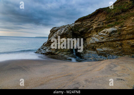 Le temps et l'eau ont sculpté en forme de serrure d'une ouverture dans la falaise à Spit Beach à St Austell Cornwall. Banque D'Images