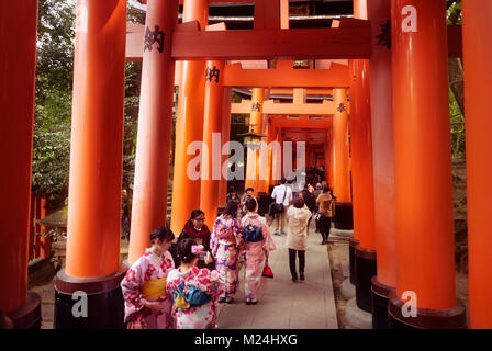 Les touristes et les femmes en kimono à marcher le long d'un long chemin, Senbon Torii torii, une rangée de portes orange, au sanctuaire Fushimi Inari Taisha Temple Fushimi Ward en tête Banque D'Images