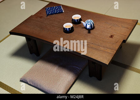 Table à thé japonais Chabudai, avec une théière et deux tasses, coussins zabuton assis sur les tatami japonais traditionnel d'une chambre dans un Ryokan inn à Kyot Banque D'Images