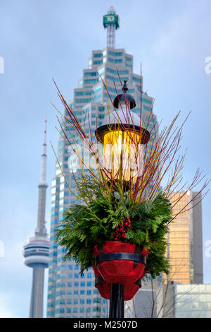 Allume la lumière de la rue décorée pour la saison de vacances comme arrière-plan de la Tour du CN et de TD Canada Trust Tower dans le centre-ville de Toronto, Canada. Banque D'Images