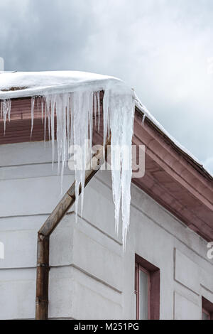 Toit de l'ancien bâtiment de ville couverte de neige et de glaçons en surplomb Banque D'Images