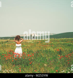 Une photo de belle jeune femme dans le champ de coquelicots Banque D'Images