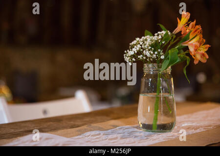 Orange et blanc arrangement de fleurs en pot sur réception de mariage table, Close up Banque D'Images