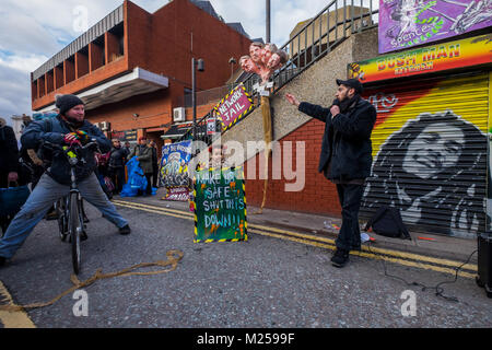 Le 5 février, 2018 - Londres, Royaume-Uni. 4e février 2018. Artiste Andrew Cooper souligne sa sculpture de theheads de Lambeth Conseillers municipaux responsables de l'épuration sociale à Aysen Dennis de l'Aylesbury Estate. Les militants le 3ème anniversaire de l'annonce par Network Rail de leurs plans visant à réaménager la Brixton des arcs avec un rassemblement et un silence de trois minutes. La région et ses petits commerçants qui ont été déplacés (quelques luttent encore pour rester) a été décrit comme le "cœur de Brixton'. Banque D'Images