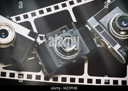 Ancienne rétro rangefinder appareil photo sur l'arrière-plan de la perforation du film Banque D'Images