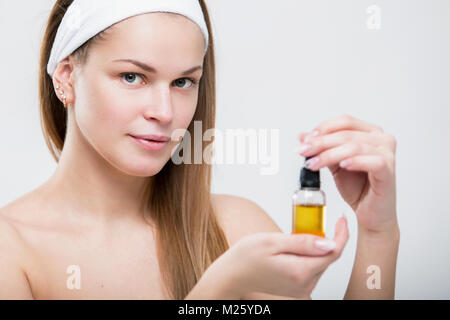 Portrait d'une belle jeune femme avec de l'huile dans les mains du visage Banque D'Images