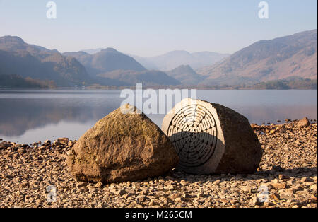 Le centenaire du National Trust en sculpture sur pierre se dresse sur les rives du lac de Derwent Water près de Keswick en Angleterre du Lake District, avec les montagnes o Banque D'Images