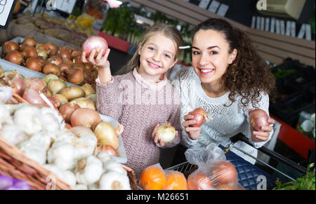 Jeune femme joyeuse petite fille avec la sélection de légumes dans un magasin d'alimentation alimentation Banque D'Images