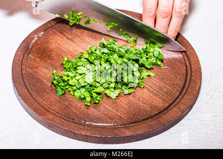 Hacher les herbes mains féminine sur planche de bois Banque D'Images