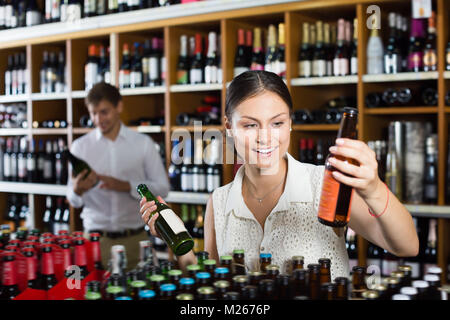 Le choix d'une femme bouteille d'alcool boisson dans wine shop Banque D'Images