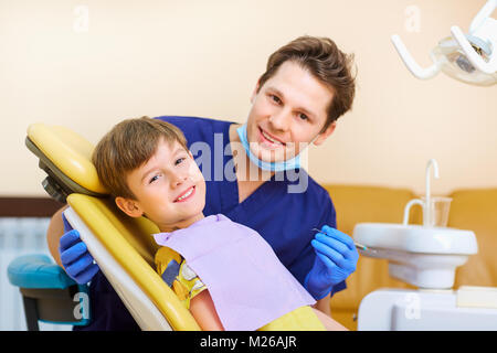 Le dentiste vérifie les dents d'un homme garçon adolescent. Banque D'Images