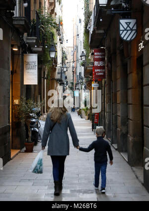 Barcelone, Espagne : Une mère et son fils tenir la main tout en marche dans une rue étroite dans le quartier Born de Barcelone. (Photo par Matt Peut/Alamy) Banque D'Images