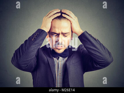 Young Woman in suit holding hands on head à la recherche désespérée. Banque D'Images