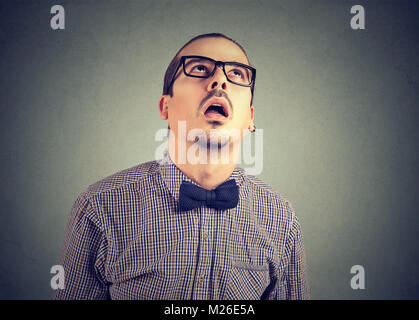 Jeune homme formelle dans les lunettes à la recherche jusqu'à l'expression de l'épuisement et l'ennui. Banque D'Images
