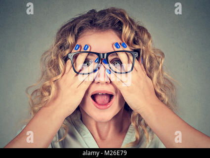 Jeune Modèle à rayures à la caméra à lunettes en couvrant les yeux et à la surprise. Banque D'Images