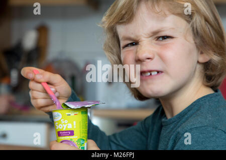 Garçon, 7 ans, goûte la nourriture végane, soja, substituer au yaourt aux fruits Banque D'Images