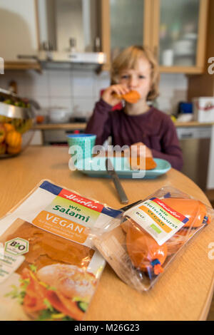 Garçon, 7 ans, végétalien, dégustation de produits de remplacement, saucisse vegan végétalien, salami, saucisses de viande Banque D'Images