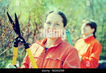 Jardinier femme coupe des branches dans le jardin au printemps Banque D'Images