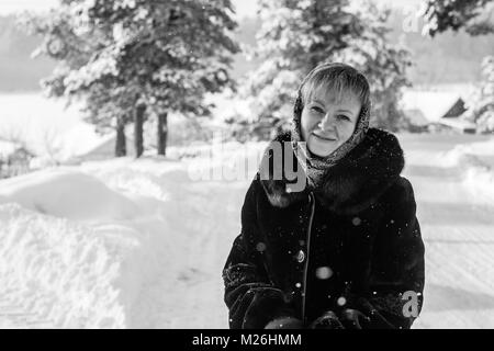 Le noir et blanc portrait de jeune femme russe dans l'hiver sur le village enneigé. Banque D'Images