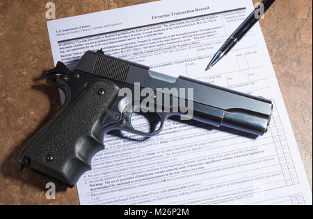 Pistolet semi-automatique de 1911 et un stylo avec l'achat de paperasse sur un compteur de tan Banque D'Images