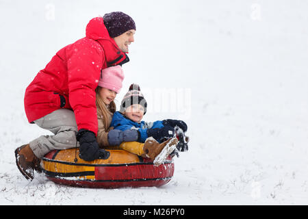 Image de l'heureux père, fille et fils de tubulure dans winter park Banque D'Images