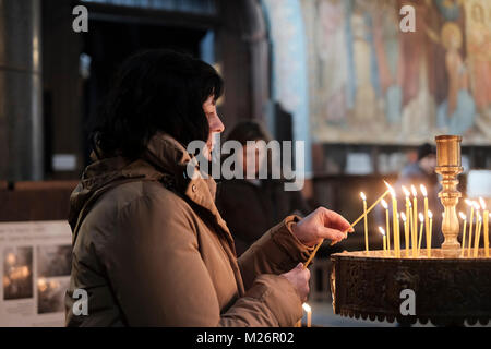 Une femme bulgare allume des bougies à l'intérieur de l'église orthodoxe Sainte-Hagia Nedelya, dans la ville de Sofia, capitale de la Bulgarie. Banque D'Images