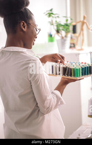 Couturière africaine holding bobines avec filetage Banque D'Images