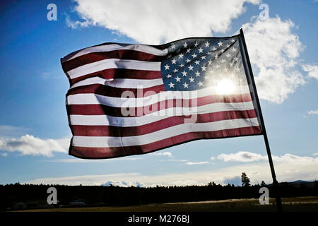 Un drapeau américain dans une forte brise à l'entrée d'une ferme rurale dans la région de Deschutes Comté (Oregon) Banque D'Images