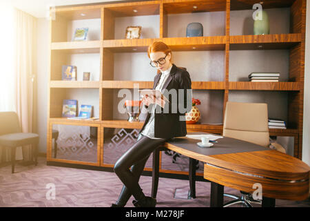 Attractive businesswoman travaillant sur une tablette numérique dans l'office. Banque D'Images