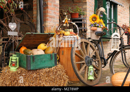 Cour de ferme avec les citrouilles et vieilles roues de bois saison d'automne Banque D'Images