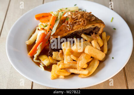 Steak and Ale Pie servi avec des frites. L'est un mets populaire British pub repas. Banque D'Images