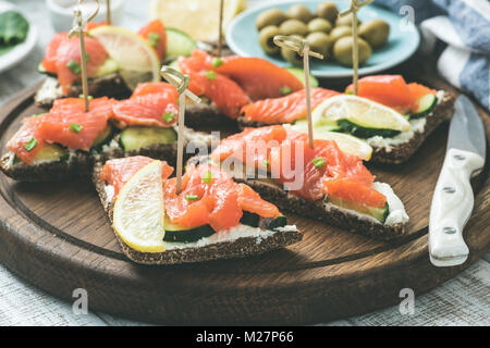 Canape avec fromage à la crème de saumon sur planche de bois. Selective focus, tonique libre Banque D'Images
