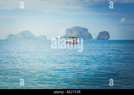 Belle vue du paysage marin bateau vitesse solitaire flottant sur la mer et l'île avec ciel bleu en arrière plan à Railay Beach, province de Krabi, Thaïlande. Banque D'Images