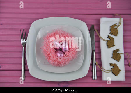 Table de pâques avec réglage de décorations et d'un nid d'oeufs de Pâques au chocolat Banque D'Images