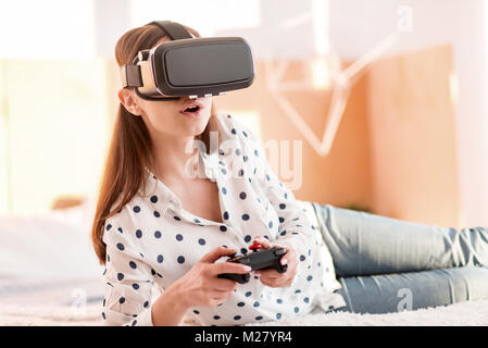 Jeune femme fasciné affecteront au jeu VR Banque D'Images