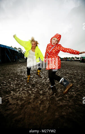 Twoyoung les filles sont d'avoir un grand temps à danser dans la boue à une année pluvieuse au Danish music festival Roskilde Festival. Danemark 2007. Banque D'Images