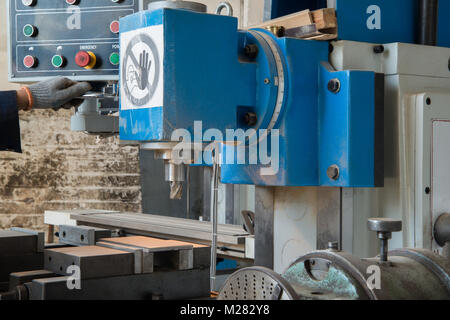 Machine de forage. Un travailleur d'usine exploite une machine à bois Banque D'Images