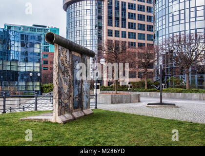 Berlin, Mitte,Moabit. Morceau du mur de Berlin & sculpture en bronze de l'homme mur briser par Rolf Bibi - symbole de la chute du Mur de Berlin Banque D'Images