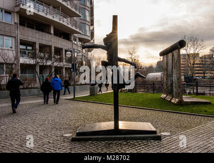 Berlin, Mitte,Moabit. Morceau du mur de Berlin & sculpture en bronze de l'homme mur briser par Rolf Bibi - symbole de la chute du Mur de Berlin Banque D'Images