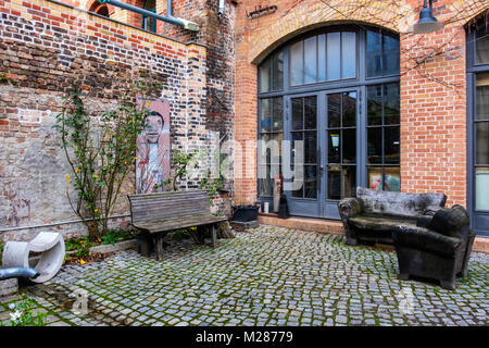 Berlin Prenzlauerberg,, cour intérieure de l'ancienne brasserie Königstadt. Bureau avec oudoor coin salon avec divans vieux banc,et l'art. Banque D'Images