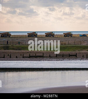 Convoi de camions à benne sur le seigle coast déménagement shingle Banque D'Images