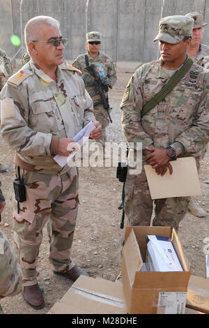 Un officier de l'armée américaine de l'Iraq et le Sgt. Chadwick Dile affecté à la 536e compagnie de maintenance, support 275e Bataillon de soutien au maintien en puissance de combat, parler de certains des articles médicaux d'être transféré à l'armée iraquienne à la gamme Besmaya complexe, l'Iraq, le 28 janvier 2018. Les États-Unis fournissent la formation et l'équipement de l'objet les forces de sécurité irakiennes à travers le National Defense Authorization Act de l'exercice 2015 ; former et équiper l'Iraq Fonds. La formation et l'équipement est à l'appui de la Force opérationnelle interarmées - fonctionnement inhérentes à la mission de résoudre la défaite et refuser l'ISIS de refuge en créant et en permettant aux peuple iraquien Banque D'Images