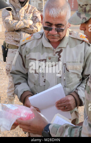 Un officier de l'armée irakienne reçoit des dispositifs respiratoires orale lors d'une livraison de matériel médical à l'armée iraquienne à la gamme Besmaya complexe, l'Iraq, le 28 janvier 2018. Le sergent de l'armée américaine. Chadwick Dile, gauche, et le 1er lieutenant Grisel Davila, centre, tous deux assignés à la 536e compagnie de maintenance, support 275e Bataillon de soutien au maintien en puissance de combat, d'afficher un mannequin pour un chef de l'armée irakienne au cours d'un transfert d'équipement médical à la gamme Besmaya complexe, l'Iraq, le 28 janvier 2018. Les États-Unis fournissent la formation et l'équipement de l'objet les forces de sécurité irakiennes à travers le National Defense Authorization Act de l'exercice 2015 ; l'Irak Tra Banque D'Images