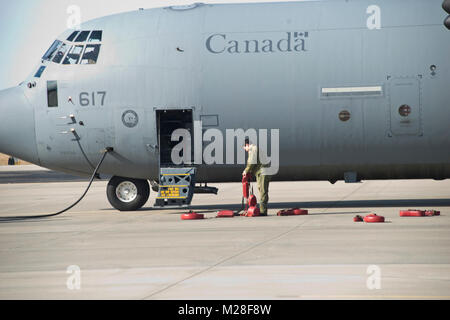 Un membre de la Force Aérienne Royale Canadienne des cales les roues de son CC-130J à Rosecrans Memorial Airport, St Joesph, Février 1, 2018 Ve après un vol d'entraînement pour le Traité sur le régime "Ciel ouvert". Le personnel de la United States, Canada, Royaume-Uni, la France et la République tchèque ont participé à ce vol conçu pour promouvoir la coopération internationale et de la transparence. (U.S. Air National Guard Banque D'Images