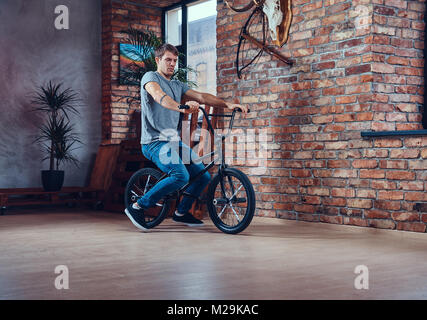 Un bel homme avec le BMX dans un studio. Banque D'Images