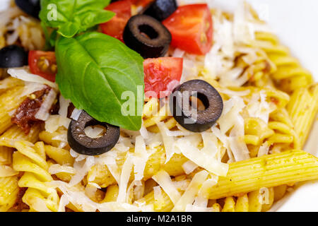 Fusillis et Penne aux tomates, olive, parmesan et basilic. Banque D'Images